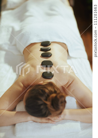 woman having hot stone massage and laying on massage table woman having hot stone massage and laying on massage table 111281663