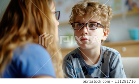 Child with autism syndrome with glasses looks at a speech therapist. Generated AI 111281716