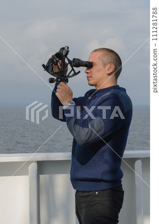 Seaman with sextant on navigational bridge 111281788