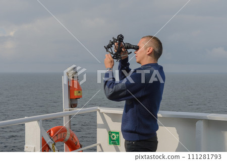 Seaman with sextant on navigational bridge 111281793