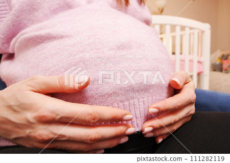 Pregnant woman sitting in a blue chair. Stroking the baby waiting for a new life 111282119