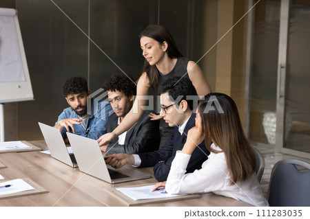 Confident busy coach woman training diverse team of new employees Confident busy coach woman training diverse team of new employees 111283035