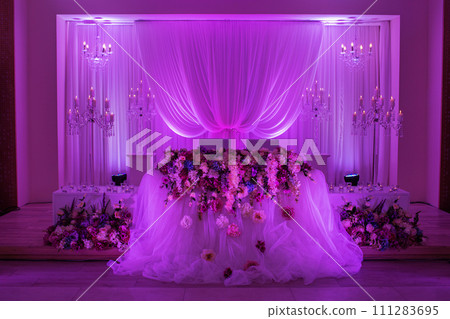 festive table for the bride and groom decorated with cloth, candlestick and flowers. wedding decoration with purple light 111283695