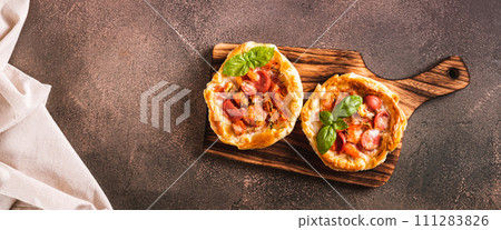 Chicago pizza pot pie with tomatoes, cheese and sausage on a wooden board top view web banner Chicago pizza pot pie with tomatoes, cheese and sausage on a wooden board top view web banner 111283826