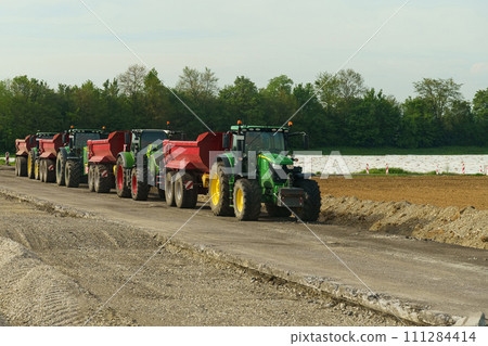 A group of tractor-dump trucks standing on a road section being repaired. A group of tractor-dump trucks standing on a road section being repaired. 111284414