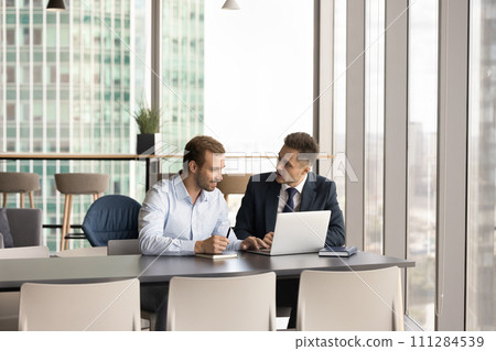 Two positive business partners men talking at workplace 111284539