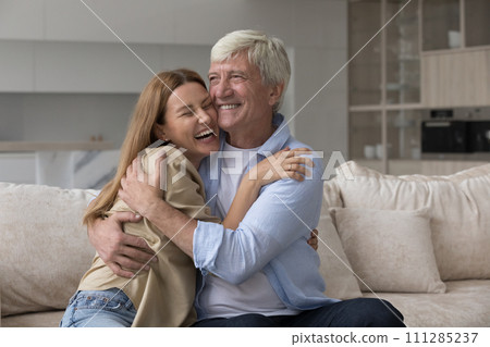 Laughing excited woman cuddle older father feeling unconditional love Laughing excited woman cuddle older father feeling unconditional love 111285237