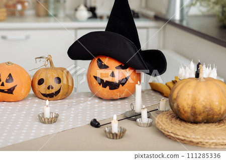 Halloween pumpkin head jack lantern with burning candles. illuminated halloween pumpkins with candles in the kitchen. Halloween pumpkin head jack lantern with burning candles. illuminated halloween pumpkins with candles in the kitchen. 111285336