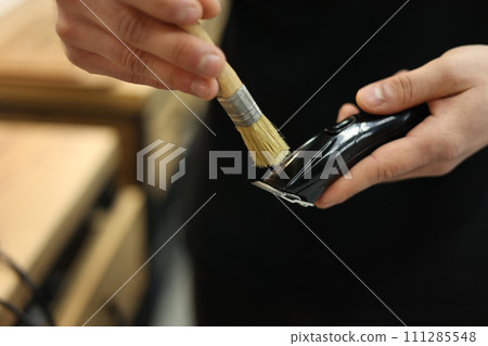man is cleaning an electric hair clipper, trimmer brush at barber shop. beauty concept man is cleaning an electric hair clipper, trimmer brush at barber shop. beauty concept 111285548