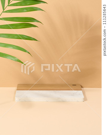 Wooden platform, shadow from a palm leaf on a brown background. 111285643