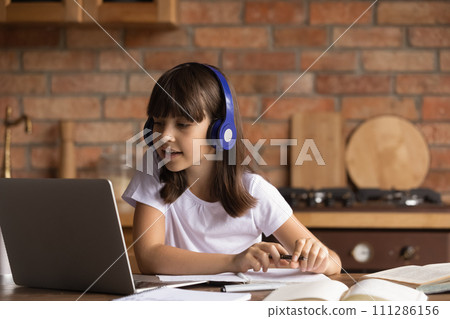 Schoolgirl in headset sit by laptop use virtual classroom software Schoolgirl in headset sit by laptop use virtual classroom software 111286156