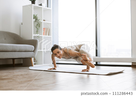 Strong woman doing power yoga during training indoors. Strong woman doing power yoga during training indoors. 111286443