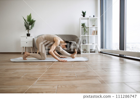 Senior woman in beige sport attire having active workout. 111286747