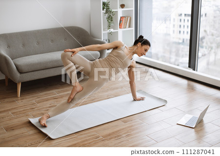 Active slim ladie building overall flexibility using Vasisthasana exercise. 111287041