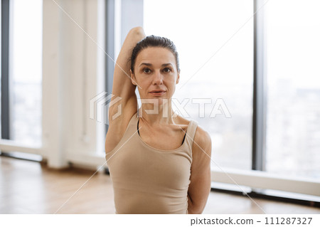 Portrait of lady in sportswear exercising due to daily yoga workout routine. 111287327