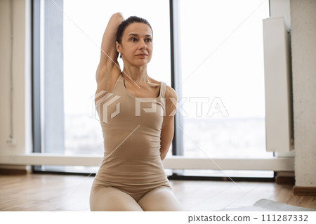 Portrait of lady in sportswear exercising due to daily yoga workout routine. Portrait of lady in sportswear exercising due to daily yoga workout routine. 111287332