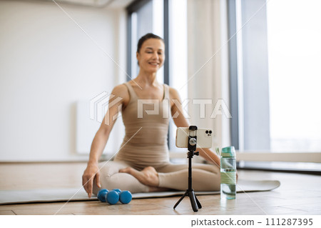 Blogger shooting video content on smartphone for own followers about meditation. 111287395