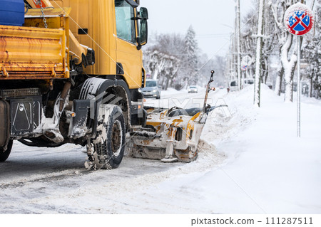 A snowplow is shoveling snow on the street, severe winter with lot of snow A snowplow is shoveling snow on the street, severe winter with lot of snow 111287511