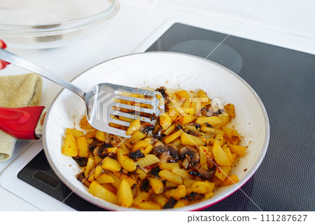 Fried potatoes with mushrooms in frying pan Fried potatoes with mushrooms in frying pan 111287627