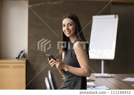 Happy beautiful Latin business leader woman holding smartphone Happy beautiful Latin business leader woman holding smartphone 111288452