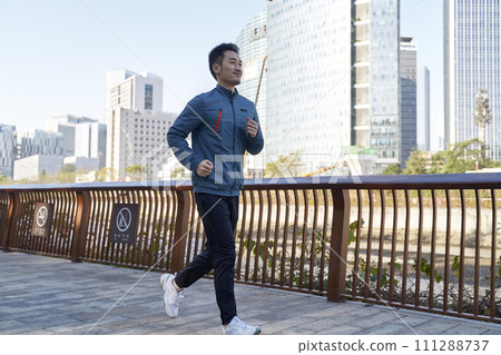 young asian man running jogging in city park young asian man running jogging in city park 111288737