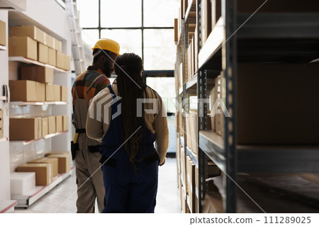 African american distribution supervisor and warehouse assistant searching parcel in storage room. Storehouse worker helping logistic manager doing inventory in storehouse African american distribution supervisor and warehouse assistant searching parcel in storage room. Storehouse worker helping logistic manager doing inventory in storehouse 111289025