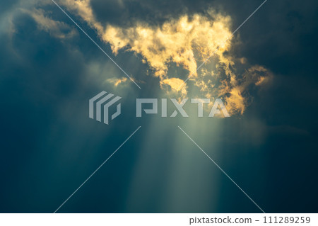 Crepuscular rays of light shining through the gap between thick clouds f-1 111289259
