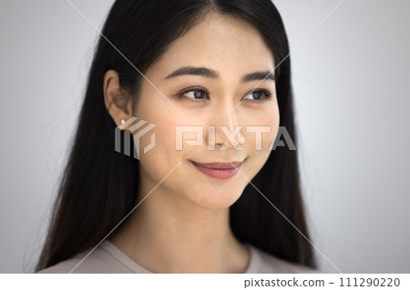 Positive beautiful young Asian woman close up casual portrait 111290220