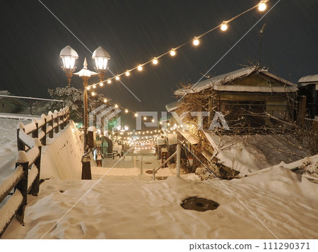 Ikaho Onsen in the snow, night view of stone steps street 111290371
