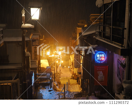 Ikaho Onsen in the snow, night view of stone steps street 111290372