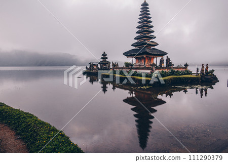 Reflection in the cloudy day of Pura Ulan Danu Bratan a famous picturesque landmark and a significant temple on the shores of Lake Bratan in Bali, Indonesia. 111290379