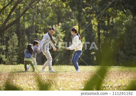 young asian family with two children enjoying outdoor activity young asian family with two children enjoying outdoor activity 111291192