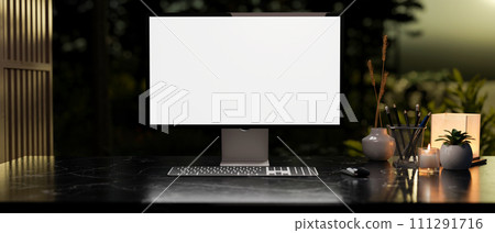 Modern dark workspace with a white-screen computer mockup and accessories arranged on a table. 111291716
