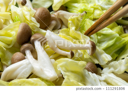高麗菜和姬菇在煎鍋中炒的烹飪場景。 111291806