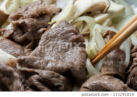 牛肉、洋蔥和蘑菇在煎鍋中炒的烹飪場景。 111291819
