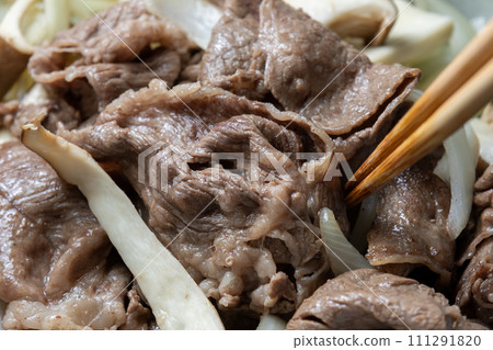 牛肉、洋蔥和蘑菇在煎鍋中炒的烹飪場景。 111291820