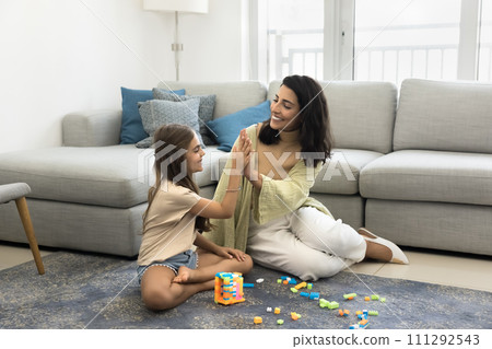 Joyful Latin mom and cheerful daughter girl giving high five 111292543
