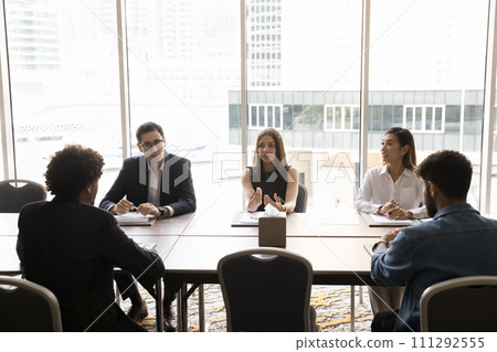 Young business leader woman talking to diverse team of colleagues Young business leader woman talking to diverse team of colleagues 111292555