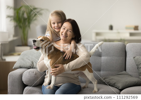 Cheerful grandmother and dog owner woman cuddling beagle Cheerful grandmother and dog owner woman cuddling beagle 111292569