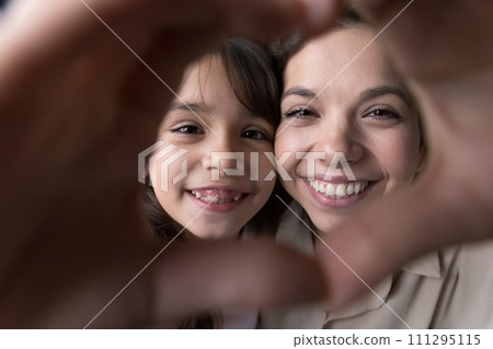 Close up faces, little girl and mother look at camera 111295115