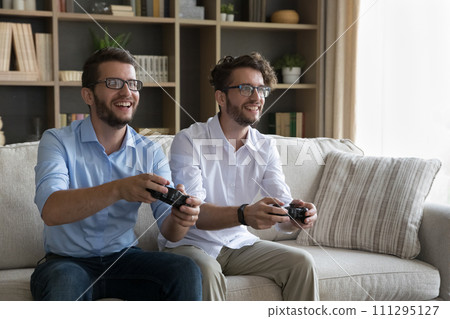 Two cheerful twins brothers playing online video game at home 111295127