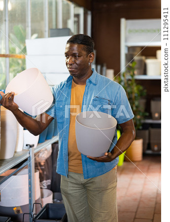 Portrait of african american man choosing pots for flowers and trees in market 111295411