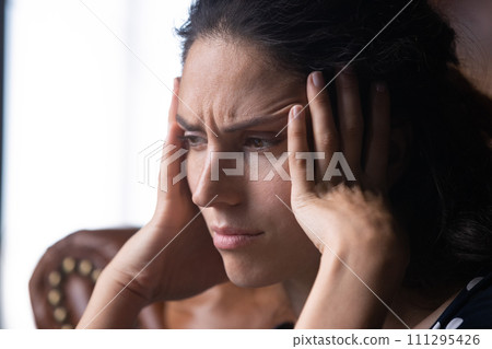 Close up hopeless frustrated woman touching temples, suffering from migraine 111295426