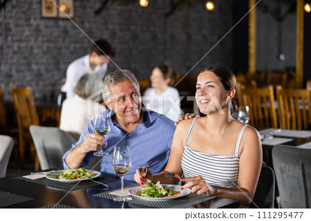 Senior man spending time with young girl in restaurant 111295477