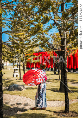 Asian girl in kimono and umbrella in Japanese theme park Hinoki Land in Chai Prakan District, Chiang 111295872