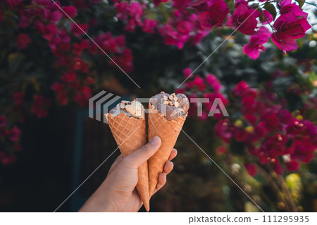 hand holding ice cream with flower background hand holding ice cream with flower background 111295935
