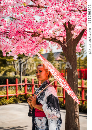 Asian girl in kimono and umbrella in Japanese theme park Hinoki Land in Chai Prakan District, Chiang 111296891