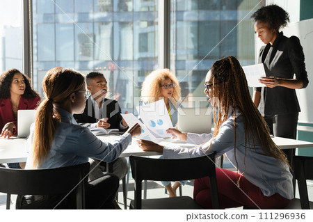 Multiethnic staff discuss sales result on briefing using paper reports Multiethnic staff discuss sales result on briefing using paper reports 111296936