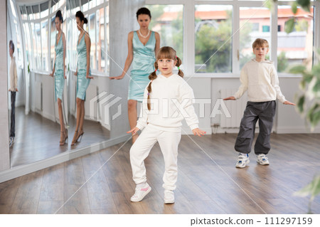 Preteen girl rehearsing funny Charlie Chaplin walk in choreography studio 111297159