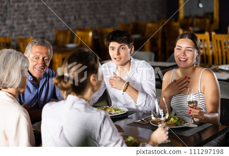 Large family, company of spouses in restaurant, eat, celebrate important event, communicate. Large family, company of spouses in restaurant, eat, celebrate important event, communicate. 111297198
